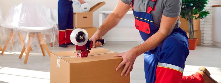 Hansen Bros. crew member packing with reusable materials and cardboard boxes