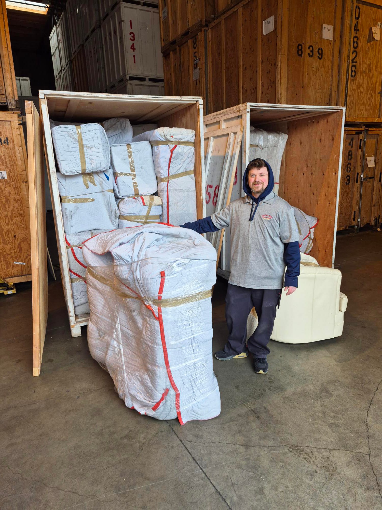 Professional mover in red polo meticulously wrapping an antique lamp